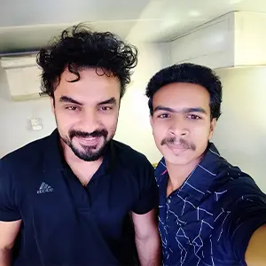 Artist Aadi, renowned as Kerala's best graphic design tutor, posing with Mollywood actor Tovino Thomas at a shooting location.